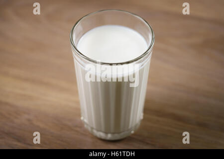 Trink Joghurt in facettiertem Glas auf Holztisch Stockfoto