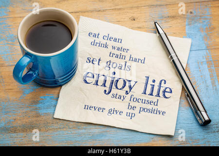 Genießen Sie das Leben - gesunde Lebensweise Wortwolke auf einer Serviette mit einer Tasse Kaffee Stockfoto