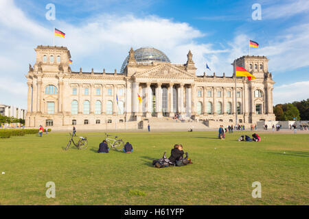 Junges Paar küssen auf einer Wiese vor Reichstagsgebäude in Berlin, Deutschland. Stockfoto