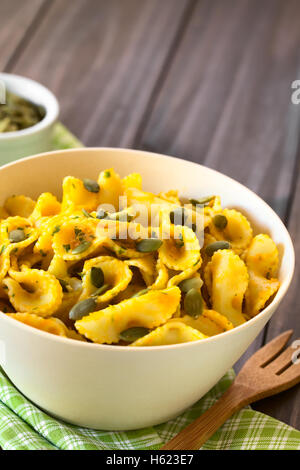 Pasta mit Kürbis und Petersilie-Sauce, mit Kürbiskernen bestreut und serviert in einer Schüssel mit Tageslicht fotografiert Stockfoto