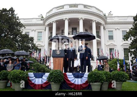 US-Präsident Barack Obama und koreanischen Präsidenten Lee Myung-Bak stehen für die US-Nationalhymne unter Sonnenschirmen während der Korea Zustand Ankunft Zeremonie auf dem Rasen des weißen Hauses Süd 13. Oktober 2011 in Washington, DC. Stockfoto