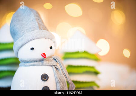 Detail der niedliche festliche Schneemann mit Weihnachtsbeleuchtung im Hintergrund Stockfoto