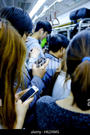 Seoul, Südkorea. 24. Oktober 2016. Leute betrachten den Handys in der u-Bahn. © Min Won-Ki/ZUMA Draht/Alamy Live-Nachrichten Stockfoto