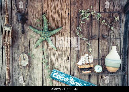 Vintage Urlaub Stillleben mit Seil, Seestern, Kompass und Flasche auf alten hölzernen Hintergrund Stockfoto