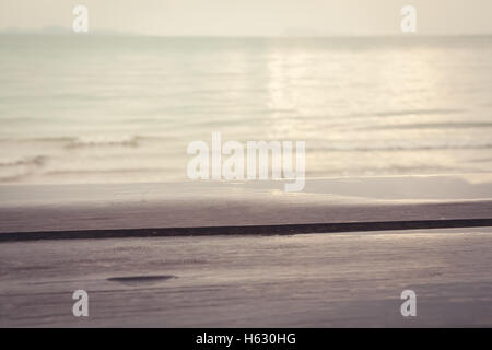 nass der Holzoberfläche nach dem Regen auf den unscharfen Hintergrund das tropische Meer bei Sonnenuntergang Stockfoto