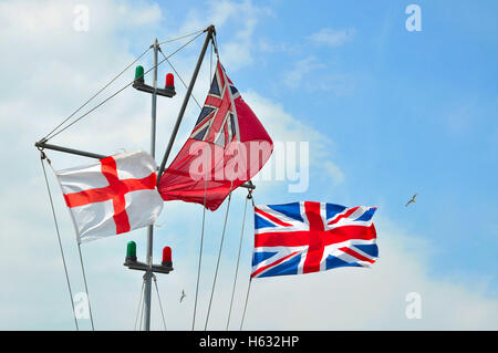 St Geoge Cross, der Handelsmarine Fähnrich und Union Jack-Flaggen auf Swanage Pier. Stockfoto