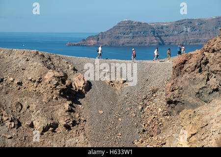 Touristen auf dem Gipfel des Vulkans in der Caldera von Santorin, Griechenland steht. Stockfoto