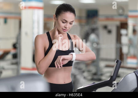 Konzentrierte Frau steuern ihr Puls nach dem Training. Stockfoto