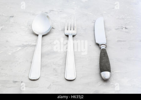 Food-Konzept - Besteck set aus Tabelle Messer, Gabel, Suppenlöffel auf Betonoberfläche Stockfoto