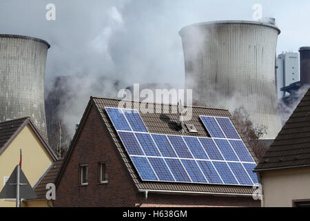 Gegensätzlichen Energien: eine solar-Strom (pv) generieren System auf einem Hausdach neben ein Kohlekraftwerk, Deutschland Stockfoto