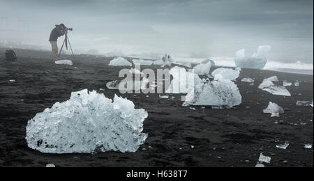 Eisbrocken vom nahe gelegenen Eisberge angespült auf einem schwarzen Sandstrand im Südosten Islands. Stockfoto