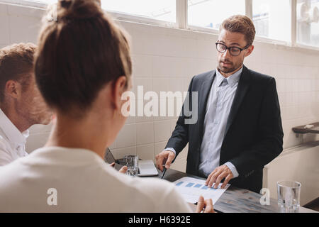 Junger Mann, neue Geschäftsideen, Kollegen zu erklären, während der Sitzung. Geschäftsleute, die treffen und brainstorming. Stockfoto