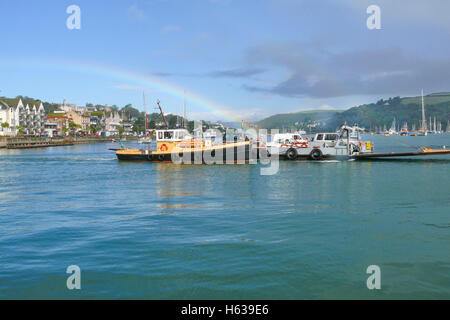 Die Dartmouth niedriger Ferry für Autos und Fußgänger lagen zwischen der Stadt und Kingswear in Mitte Fluss mit Regenbogen gesehen. Stockfoto