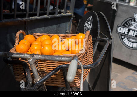 Orangen in alten Fahrrad Korb - Anzeige außerhalb Restaurant in Dartmouth Devon Stockfoto