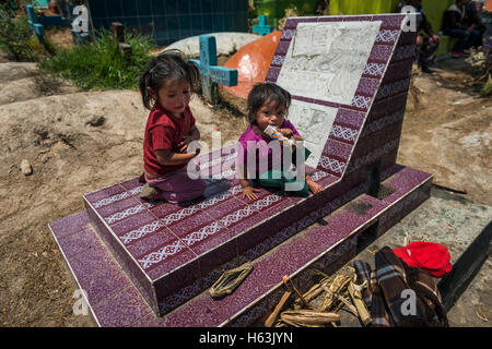 Chichicastenango, Guatemala - 24. April 2014: Kinder sitzen in einem Grab auf dem Friedhof der Stadt Chichicastenango Stockfoto