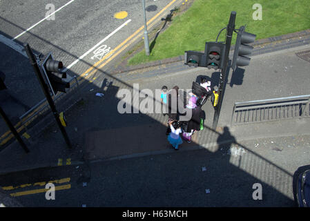 Einwanderer-Familie auf Bürgersteig in der Nähe von Ampeln, Glasgow, Schottland Stockfoto