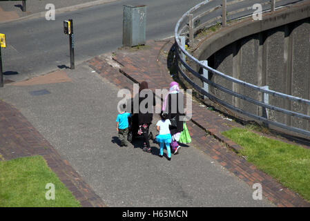 Einwanderer-Familie auf Bürgersteig in der Nähe von Ampeln, Glasgow, Schottland Stockfoto