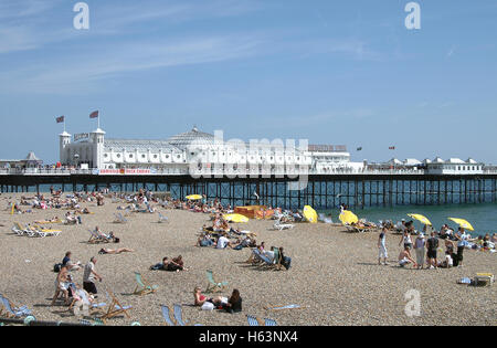 Touristen am Strand vor Brighton Pier Stockfoto