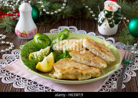Gebratener Fisch in Teig Kartoffel auf einem Holztisch Weihnachten. Stockfoto