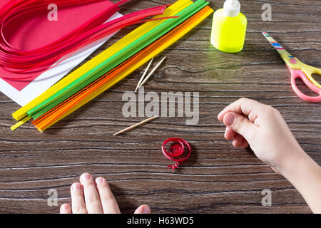 Das Kind erstellen Sie Grußkarten Origami Papier Honig und Granat Ast auf einem Holztisch. Herstellung von Papier Origami grena Stockfoto