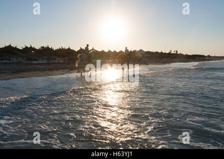 2 Reiter am Strand bei Sonnenuntergang Stockfoto