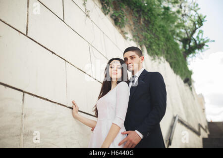 Wunderschöne Luxus Brautpaar posiert in der Nähe von großen Mauer Stockfoto