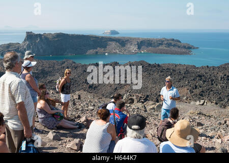 Touristen auf dem Gipfel des Vulkans in der Caldera von Santorin, Griechenland steht. Stockfoto