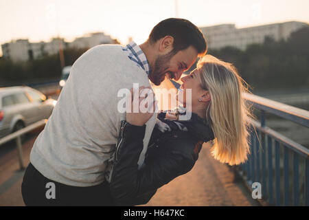 Romantisch zu zweit in den Sonnenuntergang genießen und küssen Stockfoto