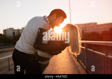 Romantisches Paar küssen in der Stadt während des Sonnenuntergangs Stockfoto