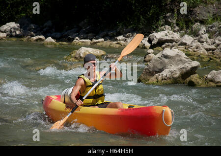 Tourismus, Tourist, Wassersport. Ein junger Mann Kanu die felsigen schnellen fließenden turbulenten Gewässern des Flusses Drôme. In der Nähe von Saillans, La Drôme, Frankreich. Stockfoto