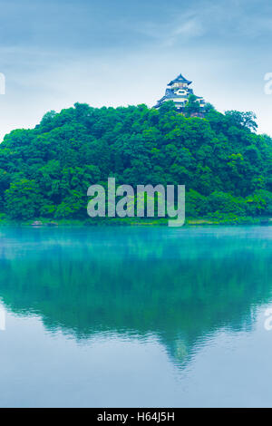 Inuyama Castle Fassade aus Entfernung hoch über Waldhügel spiegelt sich in Kiso Flusswasser am blauen Himmel Tag in Gifu Prefectur Stockfoto