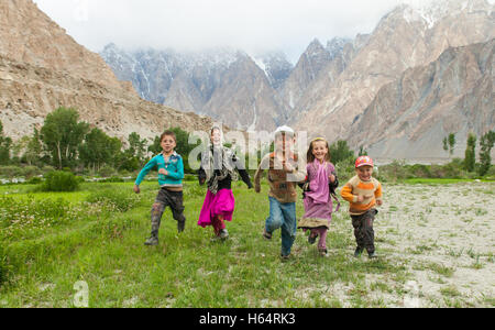 Kinder laufen zusammen in der atemberaubenden Landschaft des Karakorum-Gebirge in Passu, Nord-Pakistan Stockfoto