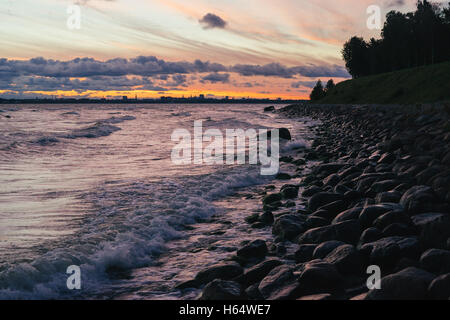 Steinige Küste der Ostsee und Tallinn City Skyline im Sonnenaufgang bis zum stürmischen Morgen Stockfoto