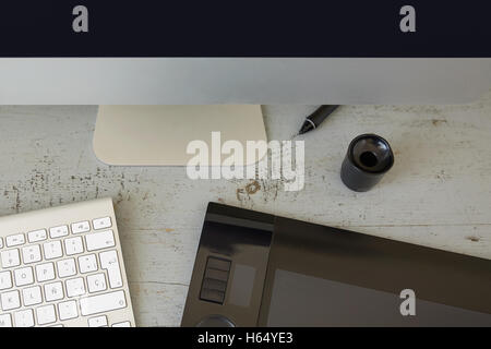 Draufsicht auf Computer, Tastatur und Grafiktablett auf Holztisch. Stockfoto