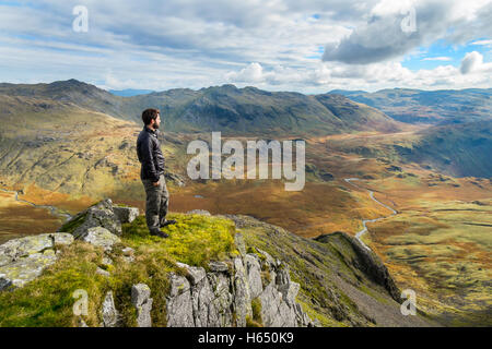 Ein männlicher Hügel-Walker Blick über große Moos im oberen Esk Valley im Lake District National Park von Scafell gesehen Stockfoto