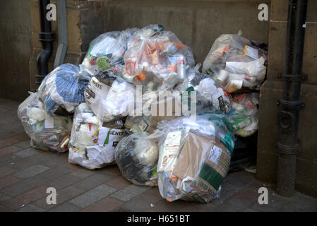 Taschen von Müll in gefliesten Gasse in der Nähe von Abflussrohre Stockfoto