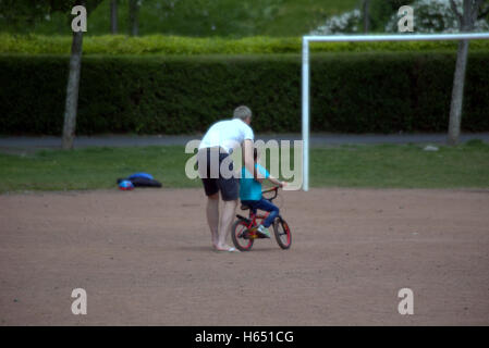 Vater lehrt Sohn Ride Bike mit dem Ziel deutlich vor ihm Stockfoto