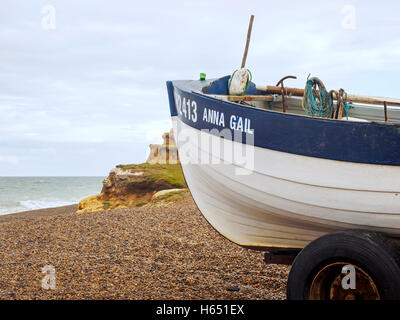 Traditionelles Norfolk Krabbe Boot holte auf der Kiesstrand am Weybourne, Norfolk mit erodieren Boulder Clay Klippen hinter Stockfoto