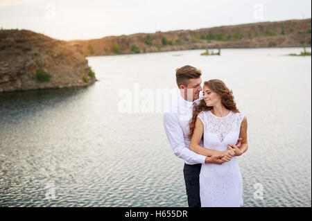 junge schöne Paar Braut und Bräutigam bei der Hochzeit Fuß am See Stockfoto