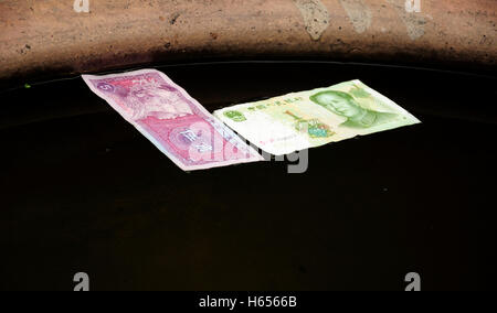 Chinesisches Geld ein Yuan und Wu Mao schwimmt auf Wasser als ein Glück im Dorf von Fenghuang in der Provinz Hunan China anbieten. Stockfoto