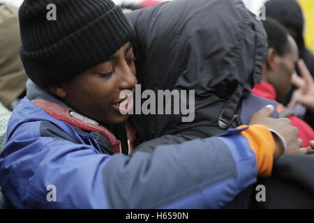 Calais, Frankreich. 24. Oktober 2016. Flüchtlinge umarmen einander, wie sie getrennt werden sollen. Der erste Tag der Registrierung und Verteilung der Flüchtlinge aus dem Dschungel in Calais hat gesehen, dass 1631 Flüchtlinge in 39 Busse von 16:00 an mehreren Orten in Frankreich verteilt wurden. Stockfoto