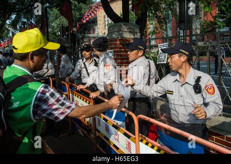 Taipei, Taipei, Taiwan. 25. Oktober 2016. Ein Gewerkschaftsmitglied übergibt ein Flugblatt an einem Polizisten bei einer Gewerkschaft Protest. Mitglieder des bürgerlichen und Arbeits-Gruppen Proest außerhalb der Gesetzgeber über Urlaub Rechte. In den letzten Änderungen an Arbeits-Vorschriften über Arbeitszeit eliminiert die Taiwan-Governmenr vor kurzem sieben Feiertage aus dem Kalender. Dies war im Gegensatz zu ihren Wahlversprechen halten die Anzahl der Feiertage um 19 Uhr. © Craig Ferguson/ZUMA Draht/Alamy Live-Nachrichten Stockfoto