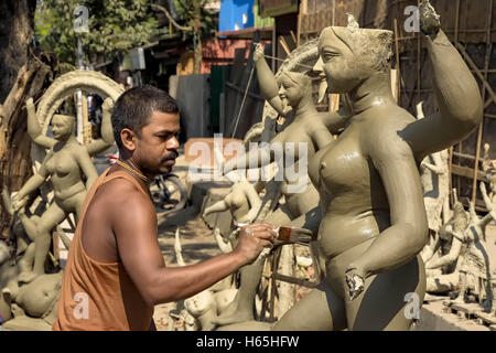 Guwahati, Assam, Indien. 25. Oktober 2016. Ein Idol Maker beschäftigt bei der Herstellung der eine Ton-Idol der hinduistischen Göttin Kali anlässlich des bevorstehenden Kali Puja & Deepawali.In dieses Schema der Ton Kunstfertigkeit, die Kunst Idol machen können werden im Zusammenhang mit Votiv Ton Elemente, aber sie tatsächlich bilden ein anderes Genre der Kunst als eine handgefertigte ungebrannten Ton-Kunst. Der traditionelle Töpferscheibe fehlt völlig, und die Arbeit erfolgt hauptsächlich durch Pressen, Formen und Verwendung einer Mischung von verschiedenen Sorten von Ton. Diese Art der Modellierung von Lehm ist relativ neu, wegen den Aufstieg und die Popularität der Götter anzubeten und Stockfoto