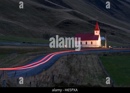 Reynisfjara Kirche beleuchtet in der Morgendämmerung mit Auto Lichtspuren, Vik ich Myrdal Southern Island, Island. Stockfoto