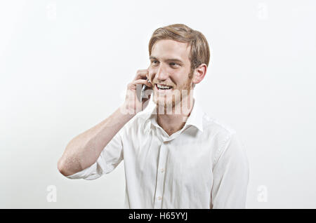 Junger Erwachsenen Mann im weißen Hemd spricht auf seinem Telefon Lächeln Stockfoto