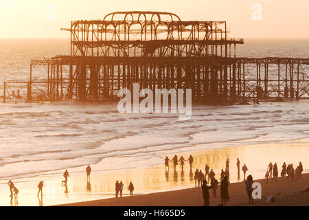 Brighton Pier West und Menschen am Strand bei Sonnenuntergang, Brighton, East Sussex England UK Stockfoto