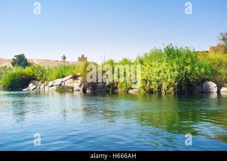 Die grüne Bank der Insel Elephantine mit dem Aga-Khan-Mausoleum auf dem Hintergrund, Aswan, Ägypten. Stockfoto