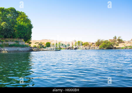 Die grüne Bank der Insel Elephantine mit dem Aga-Khan-Mausoleum auf dem Hintergrund, Aswan, Ägypten. Stockfoto