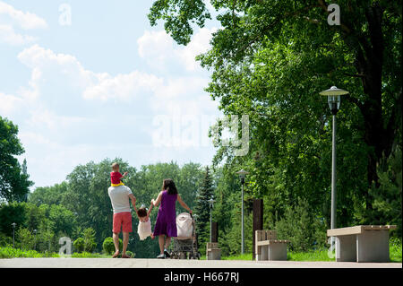Glückliche Familie von vier Personen zu Fuß im Park der Stadtzentrums Stockfoto