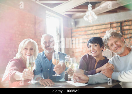 Porträt lächelnd Paare Toasten Weißweingläser am Tisch im restaurant Stockfoto